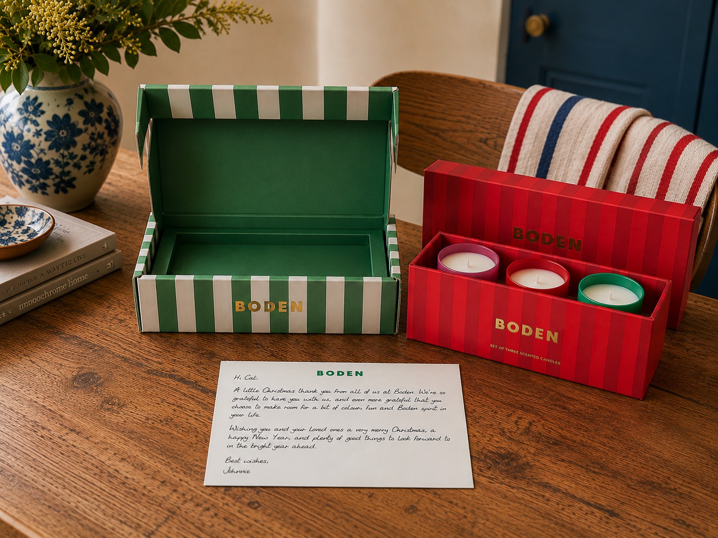 Boden branded gift box and candle set laid out alongside a personalised handwritten note